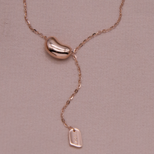 Juego de cadena y dije en oro rosado de figura irregular con plaquita colgante