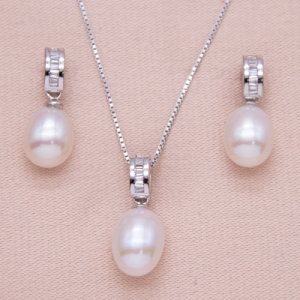 Juego de aretes con cadena y dije de perla oval con baguettes