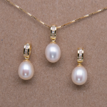 Juego de aretes con cadena y dije de perla oval con baguettes